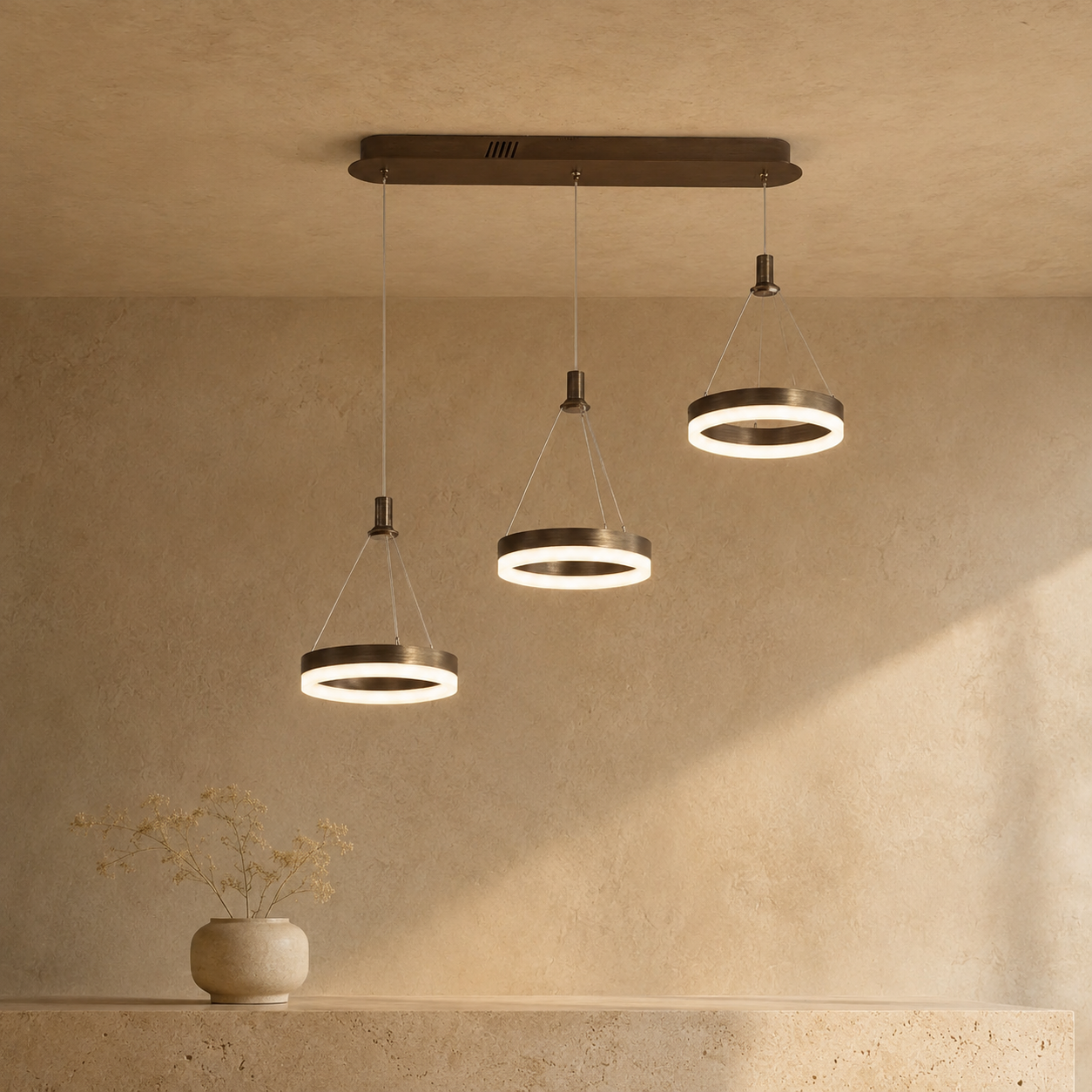 Aitu multi-light linear chandelier suspended above a kitchen island